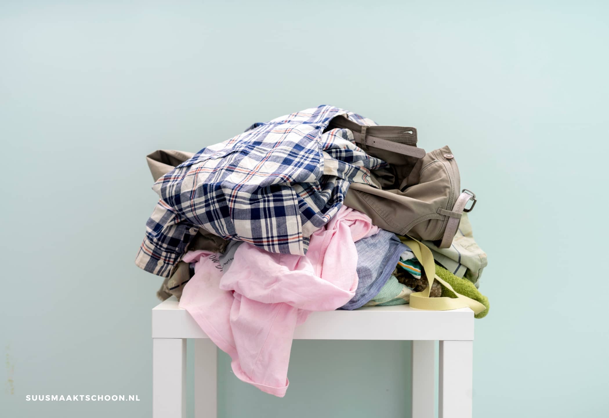 opruimtips rommelige mensen: een tafeltje met een stapel kleding erop