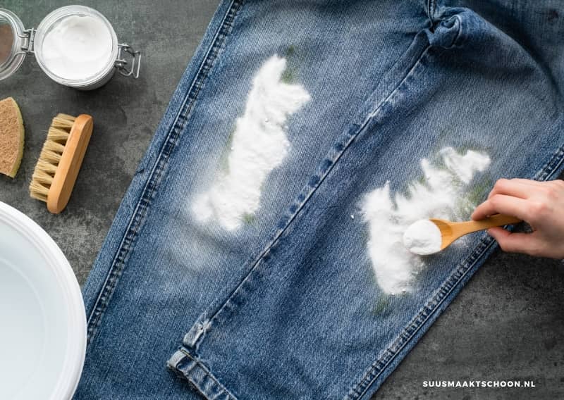 vlekken uit kleding met baking soda: jeans met baking soda eroverheen gestrooid