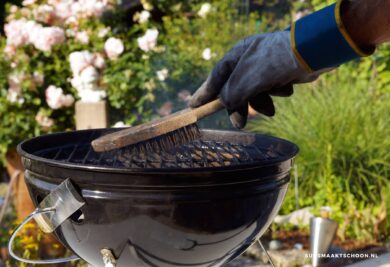bbq schoonmaken: een persoon die een barbecue schoonmaakt
