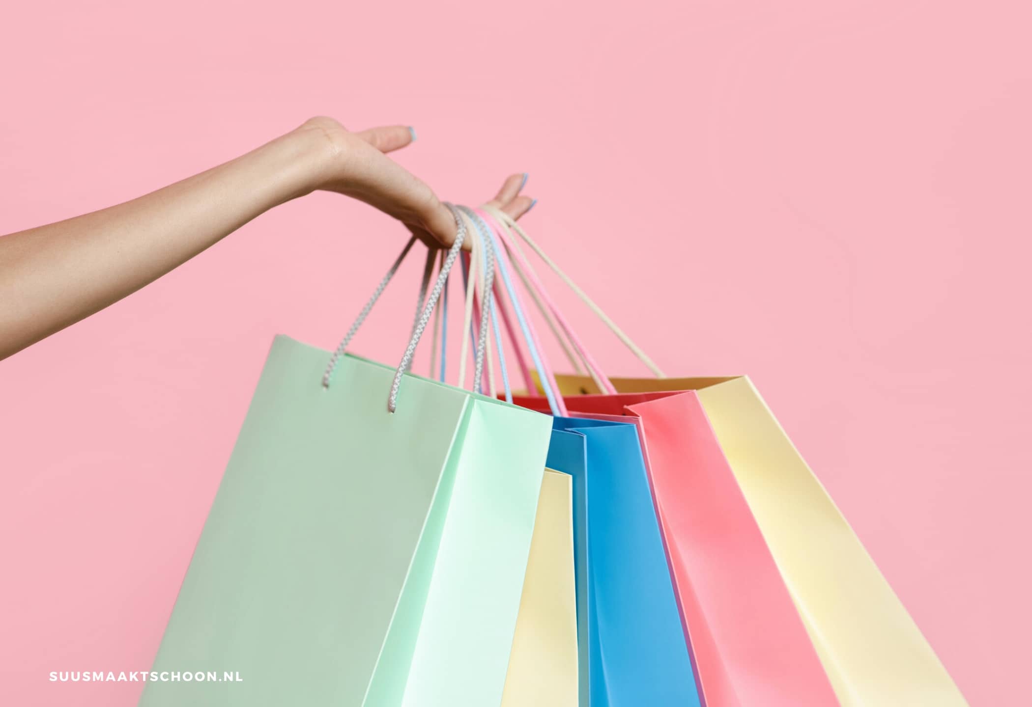 opgeruimd huis, stop met shoppen: een hand die verschillende boodschappentassen vasthoudt