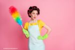 Vrouw in schort met plumeau: stoffig huis