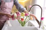 bloemen verzorgen: een persoon die bloemen wast in een gootsteen