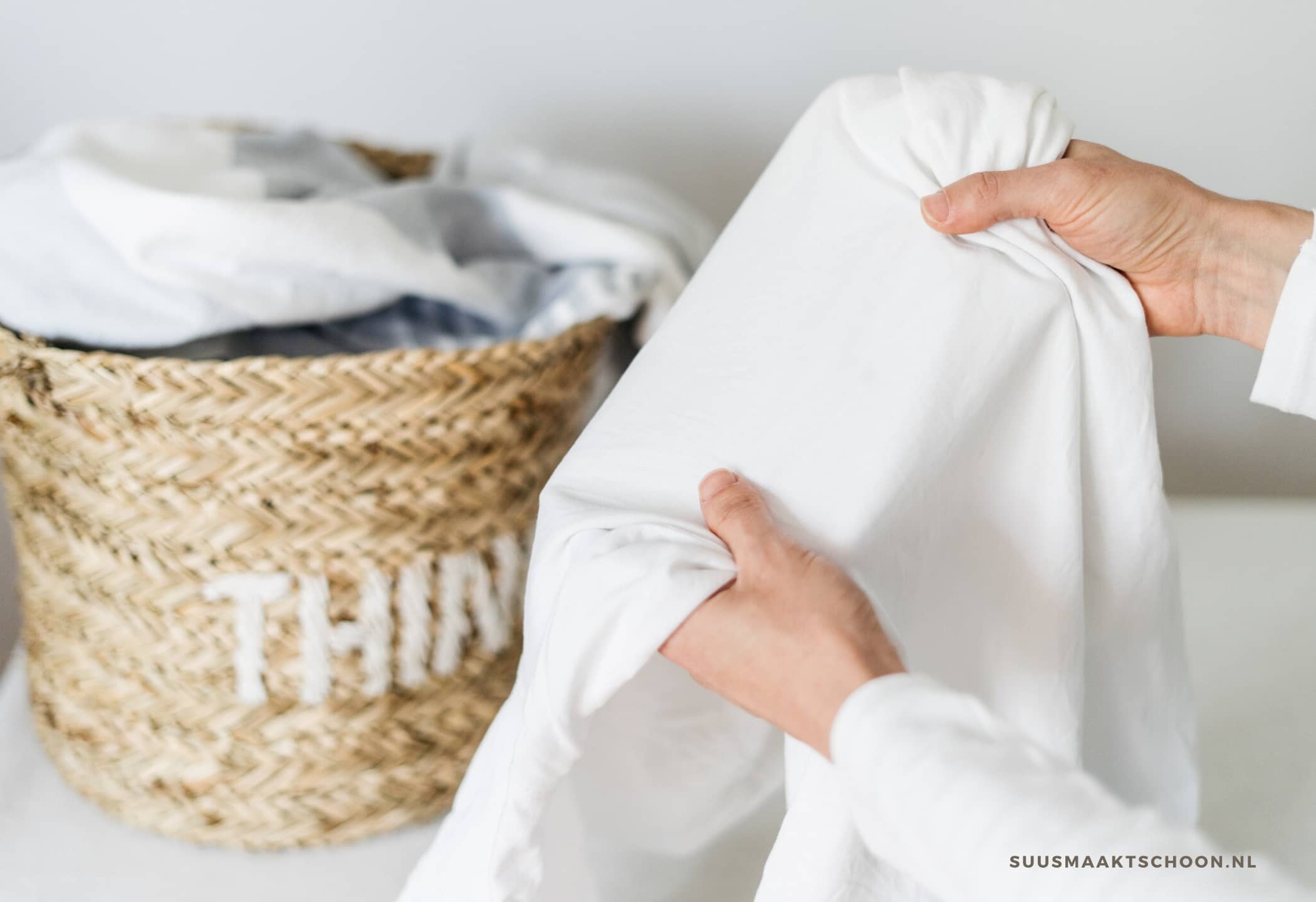 vrouw houdt wit overhemd vast en maakt witte was weer wit