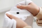 inktvlekken uit kleding: een persoon met een wit shirt met een zwarte inktvlek erop
