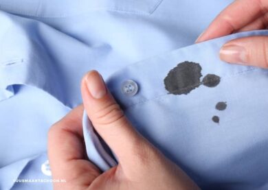 inktvlekken uit kleding: een persoon die een shirt vasthoudt met zwarte inktvlekken erop