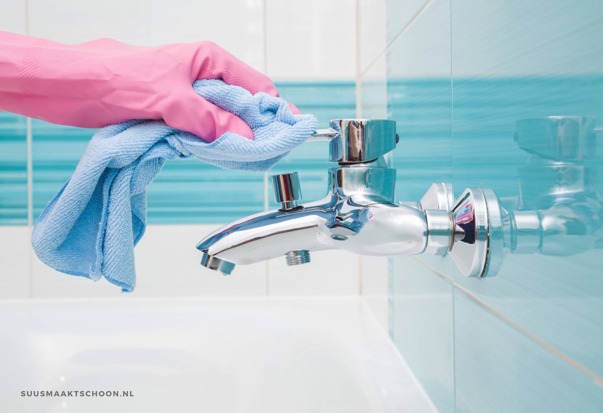 badkamer schoon: een hand in een roze huishoudhandschoen die een kraan schoonmaakt