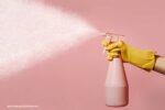 goedkope schoonmaaktips: een hand die een spuitfles vasthoudt
