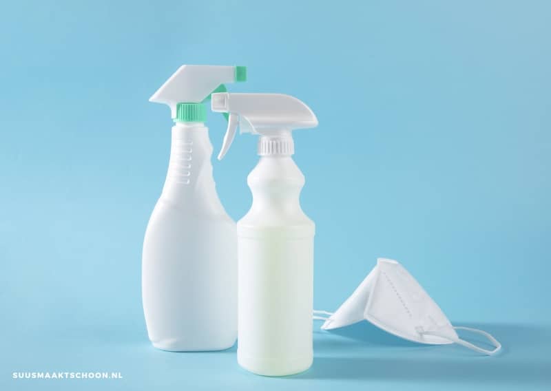schoonmaken met bleek: schoonmaakspray met mondkapje, blauwe achtergrond