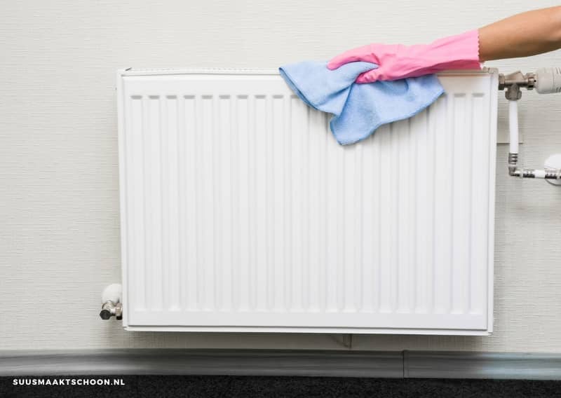 persoon buitenkant radiator schoonmaken