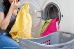 wasgoed en wasmachine stinkt, vrouw knijpt neus dicht