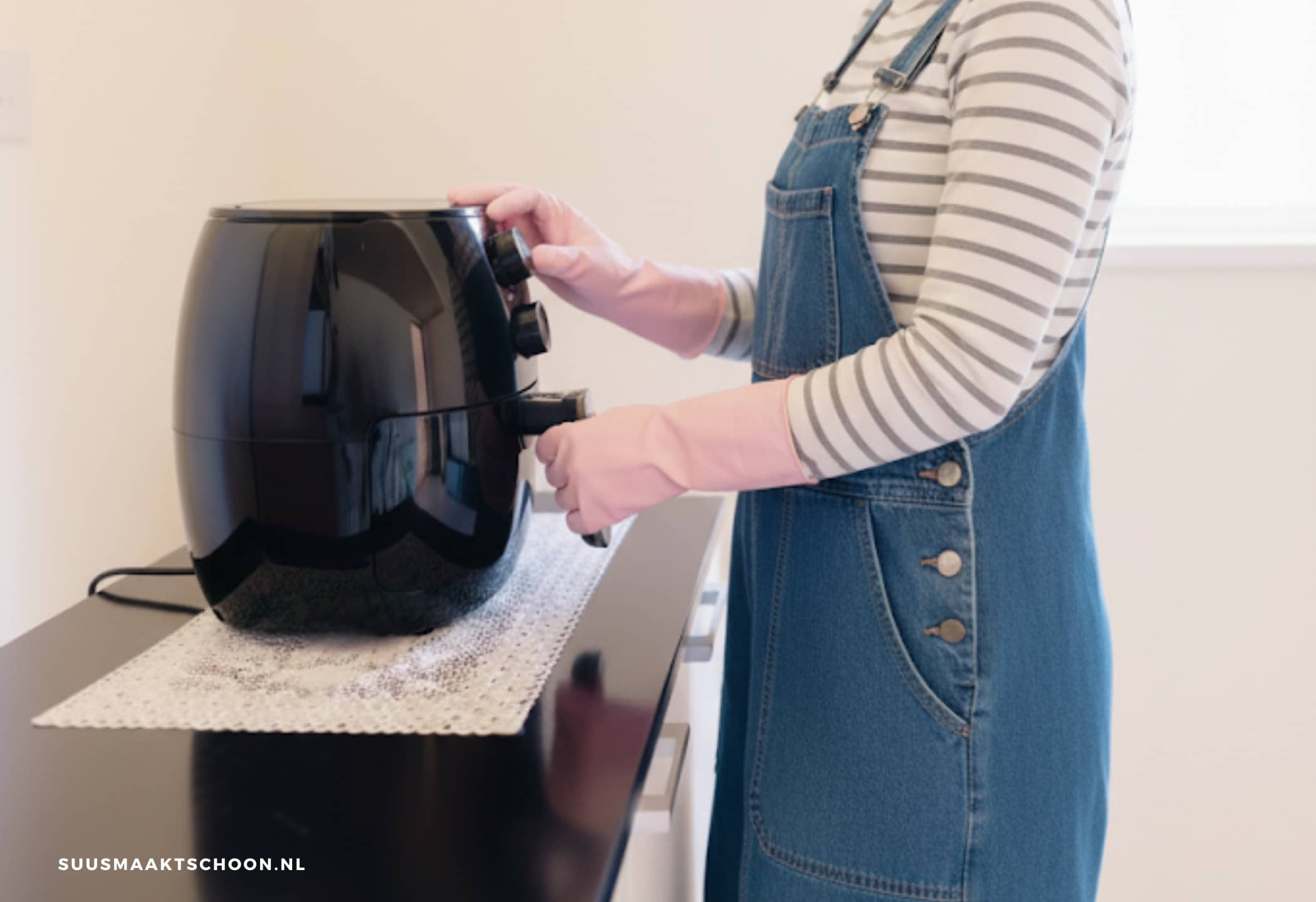 Vrouw met airfryer schoonmaken