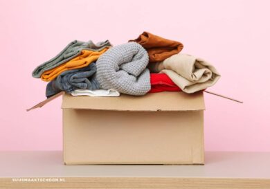 Doos met opgevouwen kleding die klaarstaat om weg te doen als onderdeel van Project 333, de minimalistische kledingchallenge waarbij je drie maanden leeft met 33 items.